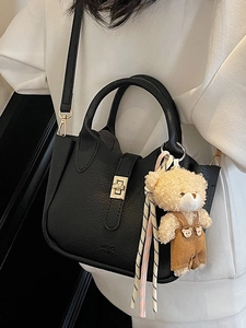 Borsa a secchiello nera con trama litchi chiusura dorata e ciondolo orsetto di peluche