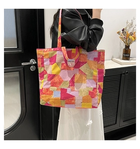 Detail view of the colorful patchwork tote bag showing a unique vibrant graffiti pattern