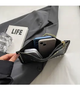 Internal view of black textured leather envelope bag with gold chain trim and large capacity