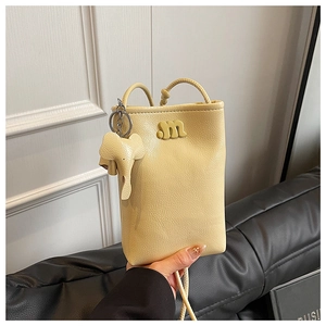 Detail of lychee pattern leather crossbody phone bag with metal M logo and elephant charm