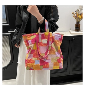 Detail of multi-color block patterned tote bag with OUR FAVE label and wide handles