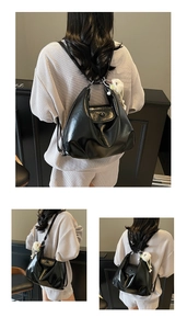 Detail of black PU leather tote bag featuring a cute white plush bear pendant