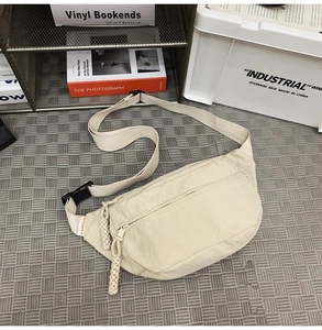 Dettaglio della borsa a tracolla in nylon beige con tracolla regolabile e zip