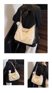 Detailed view of cream white large capacity tote bag with soft leather texture and charm