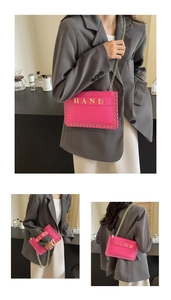 Detail of fuchsia envelope bag with gold chain strap and woven edge craftsmanship