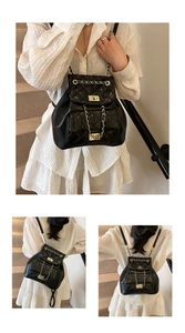 Detail of black quilted leather backpack with gold chain straps and metal twist lock