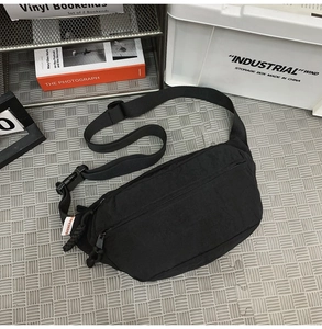 Dettaglio della borsa a tracolla nera con logo Sunian e cinturino in nylon regolabile