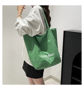 Macro detail of high-capacity green tote bag with Our fave Party print and nylon texture