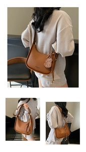 Detail of brown litchi pattern leather baguette bag with a cute dog charm and strap
