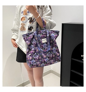 Close-up of floral tote bag with purple pansy prints and durable canvas fabric detail