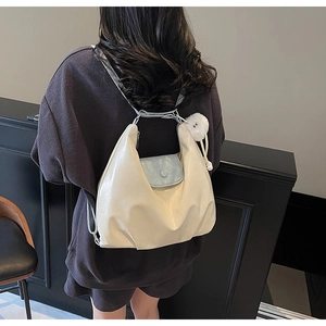 Détail du sac cabas minimaliste crème avec bordure bleue porté par un mannequin