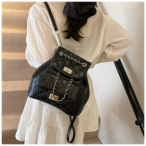 Quilted black leather backpack with gold chain straps and twist lock on a female model