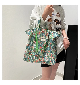 Canvas tote bag detail with floral prints and 'OUR FAVE' label shown on model
