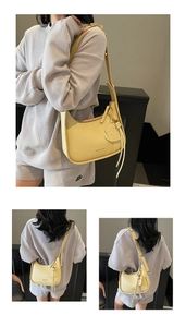 Detail view of yellow lychee texture half-moon underarm bag with cute dog pendant