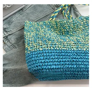Gros plan sur la texture tissée d'un sac sous les bras en paille aux couleurs contrastées
