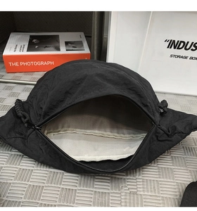 Dettaglio interno della borsa a tracolla in nylon nero con fodera a spina di pesce e cerniera
