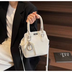 Detail of white milk carton bag with lychee grain texture and pearl ribbon charm decoration