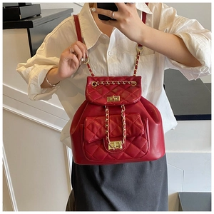 Detail shot of red quilted backpack with classic diamond stitching and gold chain straps