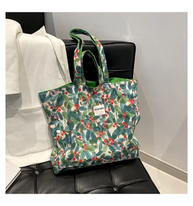 Detail of the green leaf floral canvas tote bag showing the OUR FAVE fabric label