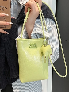Lime green pleated mini tote bag with letter M logo and elephant charm accessory