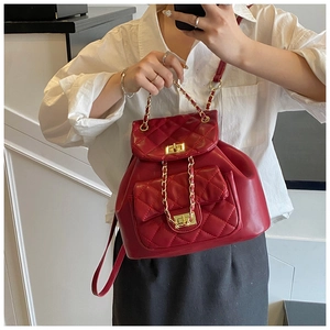 Detail of red quilted leather backpack with dual pockets and gold chain straps