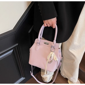 Detail of lavender lychee leather Kelly bag with silver lock and pearl bow charm accessory
