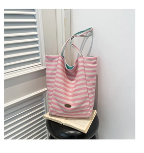 Detail view of large canvas tote bag with pink stripes and mint green interior lining