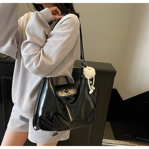 Détail du sac cabas noir brillant avec fermeture éclair et joli pendentif en peluche