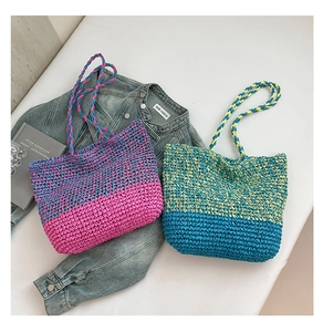 Détail de sacs fourre-tout tissés en rose et bleu avec des bandoulières en spirale
