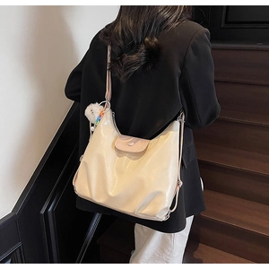 Détail du sac fourre-tout crème mat avec rabat rose et breloque en peluche
