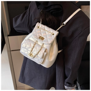 Detailed macro of white quilted faux leather texture with elegant gold chain links and clasp