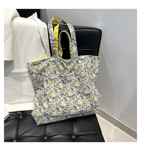 Detail shot of the floral canvas tote bag featuring vibrant lining and a white logo patch