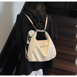 Détail du sac cabas en cuir crème avec rabat magnétique rose et breloque en peluche