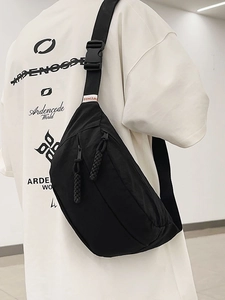 Borsa a tracolla minimalista in tessuto lavato nero indossata da un modello