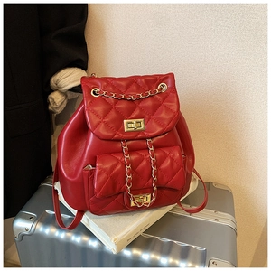 Macro shot of red quilted faux leather backpack with gold chain and twist-lock closures