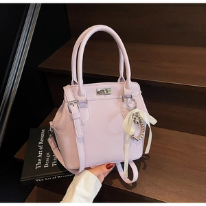 Detail of light purple milk box bag with silver clasp, pearl charm, and white bow knot