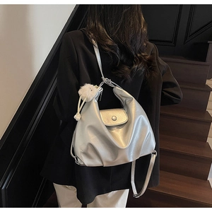 Vue détaillée du sac cabas argenté avec breloque pelucheuse sur un mannequin