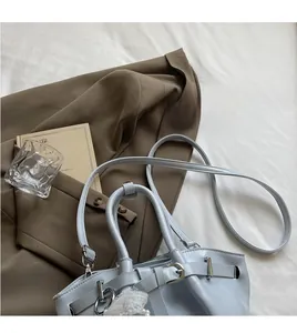Detail of light blue pleated bucket bag with pearl lace charm and smooth long strap