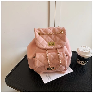 Detailed close-up of pink quilted mini backpack with gold metal turn-locks and chain straps