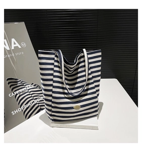 Detailed close-up of blue and white striped canvas tote bag with oval brand tag