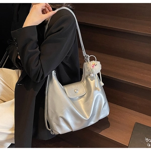 Détail du sac hobo argenté avec pendentif en peluche et boucle décorative