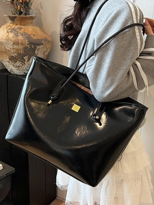 Minimalist large black tote bag in oil wax PU leather with a sleek gold logo hardware