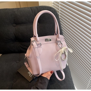 Detail shot of light purple lychee pattern handbag with silver metal turn-lock closure