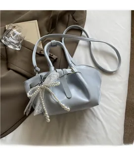 Detail of light blue pleated bucket bag with pearl lace charm and belt buckle decor