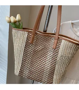 Close-up of woven straw tote bag featuring contrast stitching and brown leather handles