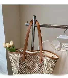 Detail of straw tote bag with brown leather straps and intricate hollow woven pattern