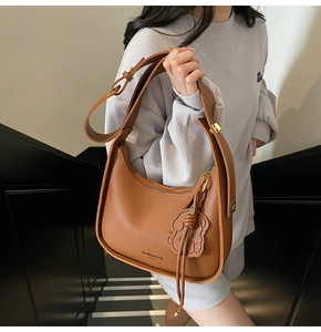Detail of caramel brown litchi pattern leather shoulder bag with New York logo