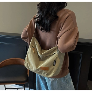 Detail of a khaki nylon crossbody tote bag showing large capacity and adjustable strap