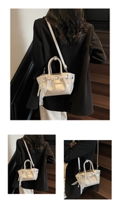Detail view of cream pleated bucket bag with pearl lace charm and crossbody strap