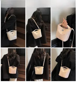 Borsa a secchiello trapuntata in vernice beige mostrata da più angolazioni su un modello